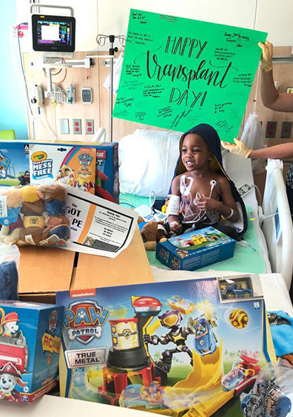 Olu sits on his hospital bed surrounded by toys on the day of his blood marrow transplant for sickle cell anemia.