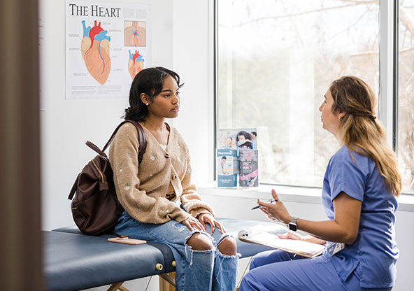 Young woman talking to nurse