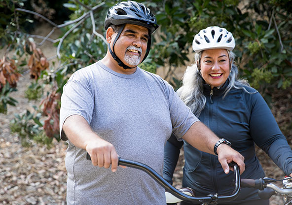 Couple enjoying a bike ride through the park to get some exercise. 