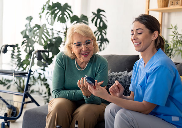 A woman and a nurse measuring glucose levels. 