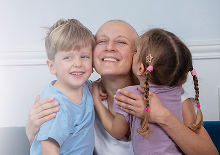 Two Kids Hugging their Grandma with Cancer