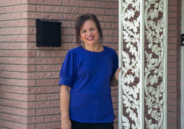 Leticia Ponce standing on the front porch of her home.